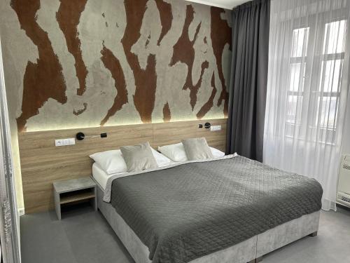 Drnholec的住宿－Hotel 14Dveří，卧室配有一张大床,墙上挂有壁画