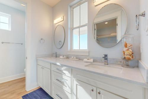 a white bathroom with a sink and a mirror at Sunset Bay in Galveston