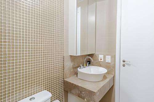 a bathroom with a white sink and a toilet at Apartamento Espaçoso & Aconchegante - 3 quartos in Porto Alegre