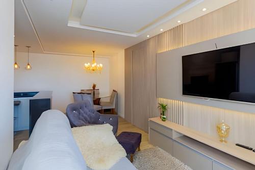 Televisyen dan/atau pusat hiburan di Apartamento Espaçoso & Aconchegante - 3 quartos c/ ar condicionado - até 12 pessoas
