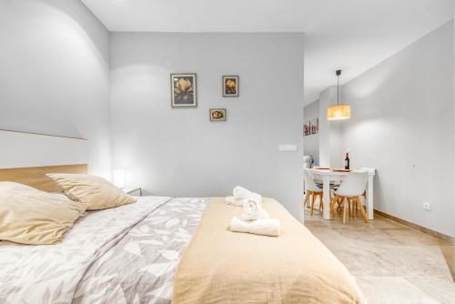 a white bedroom with a bed and a table at Lovely & Modern flat in Heart of Castellón in Castellón de la Plana