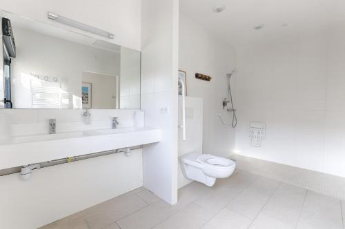 a white bathroom with a toilet and a sink at La Coudraie - Proche de Disneyland in Montévrain