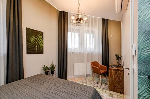 a bedroom with a bed and a chair and a window at Luxury Tropical Apartment at Budapest in Budapest