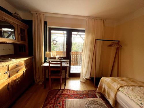 - une chambre avec un bureau, un lit et une table dans l'établissement Gemütliches Appartment "LaWendel" mit Balkon am Waldrand, à Witzenhausen