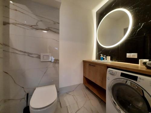 a bathroom with a washing machine and a mirror at Kępa Studio 73 in Wrocław