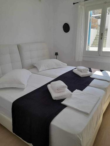 two white beds in a room with towels on them at Villa de Estrella in Agios Dimitrios