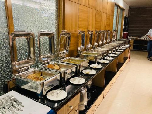 a buffet line with plates of food in a restaurant at Hotel Yuvraj Dx in Pipra Dewās