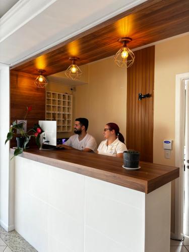 a man and a woman sitting at a bar at Hotel Lacala in Florianópolis