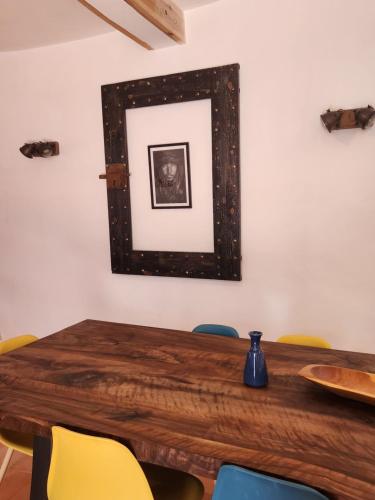 a dining room table with yellow chairs and a mirror at Villa Al Kharoube in Essaouira