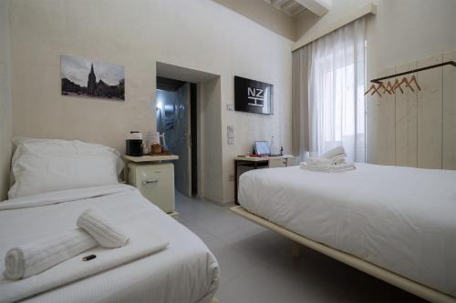 una camera d'albergo con due letti e una finestra di Nz Home a Foligno