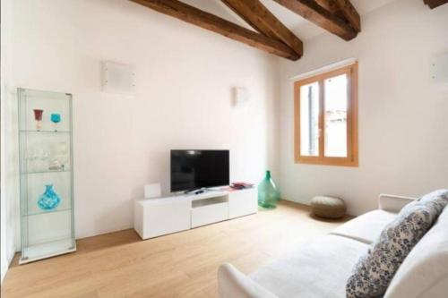 uma sala de estar com um sofá branco e uma televisão em Ve-nice Suite Casa Teresa C881 em Veneza