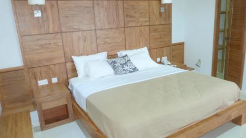 a bedroom with a large bed with a wooden wall at Sunset Bay Apartment in Glacis