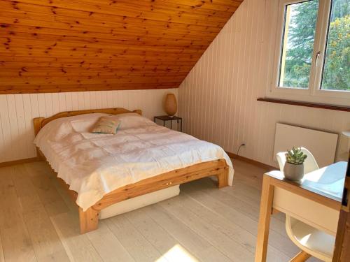 1 dormitorio con cama y techo de madera en Luxueuse oasis écologique à proximité du lac, en Preverenges