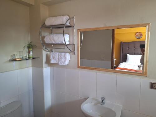 bagno con specchio, lavandino e servizi igienici di Chaska valle Inn a Urubamba