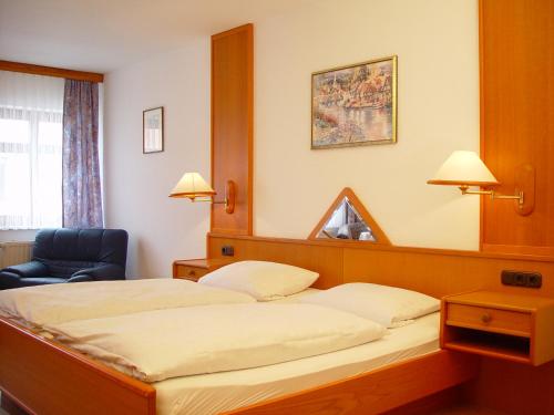 une chambre d'hôtel avec un lit et une chaise dans l'établissement Gasthaus Debelius Beltershausen, à Marbourg