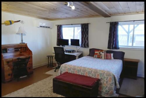 Un dormitorio con una cama, un escritorio y una computadora. en Guest Space on the Portland Peninsula, en Portland