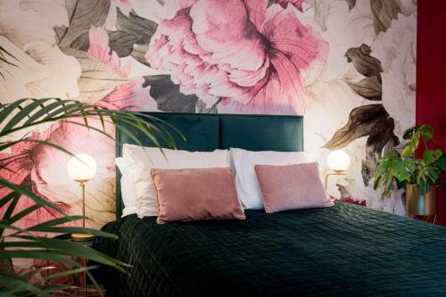 a bedroom with a bed with pink flowers on the wall at Emerald Spa Guest house in Krakow
