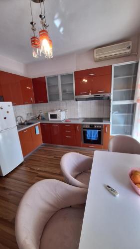 a kitchen with red cabinets and a table with chairs at CozyFlat in the middle of Tirana in Tirana