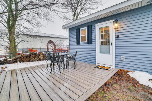 a wooden deck with a table and chairs on a house at 1 Mi to Little Traverse Bay Home with Fire Pit in Petoskey