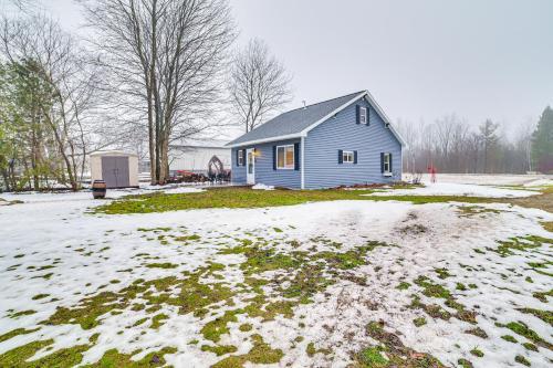 a blue house in a yard with snow at 1 Mi to Little Traverse Bay Home with Fire Pit in Petoskey