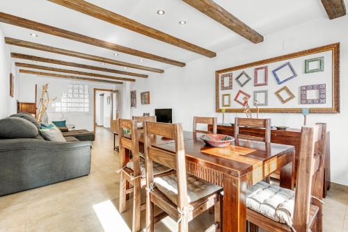 a living room with a wooden table and chairs at Luxe Mediterranean Masia BBQ Pool Chillout in Mas de Catalá