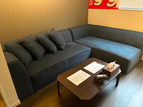 sala de estar con sofá azul y mesa en ART HOUSE-アートハウス友家tomoya- en Osaka