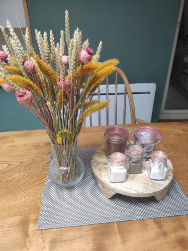 un jarrón de flores y velas sobre una mesa en Rose Cottage, en Huelgoat