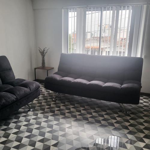 a living room with a couch and a checkered floor at Casa Azul - Apartamentos Amoblados - in Manizales
