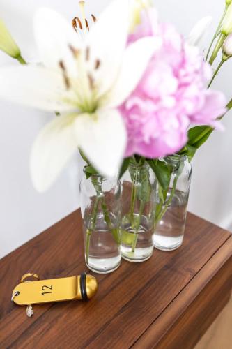 a group of vases with flowers on a wooden table at La Coudraie - Proche de Disneyland in Montévrain