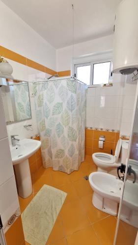 a bathroom with two toilets and a sink and a shower at CozyFlat in the middle of Tirana in Tirana