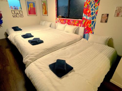 Dos camas en una habitación con toallas. en ART HOUSE-アートハウス友家tomoya- en Osaka