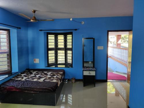 um quarto azul com uma cama e um espelho em Sea Shade em Udupi