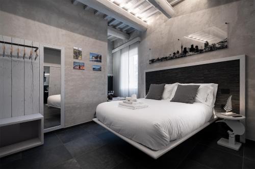 una camera da letto con un grande letto bianco e uno specchio di Nz Home a Foligno