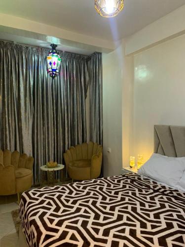 een slaapkamer met een zebrathema en een bed en 2 stoelen bij agadir hay salam in Agadir