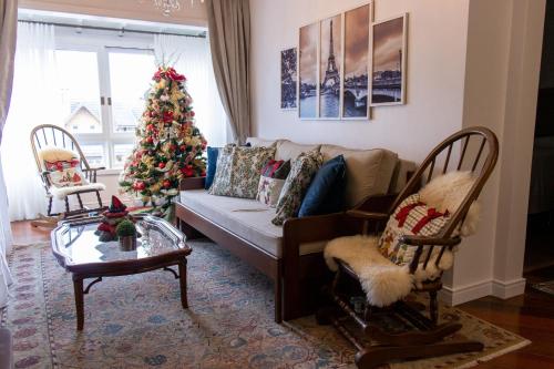 een woonkamer met een kerstboom en een bank bij Locar-in Gramado- Jardim Europa in Gramado