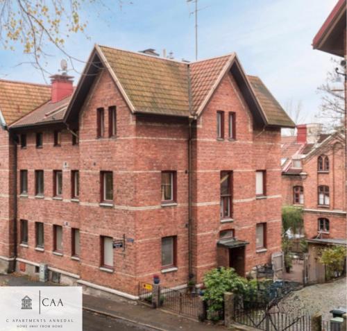 a large red brick building with a roof at C Apartments Annedal in Gothenburg