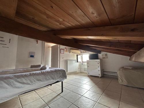 sypialnia z łóżkiem i drewnianym sufitem w obiekcie Ale e Nau w Rzymie