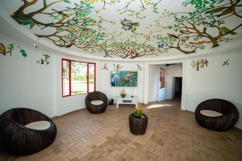 a room with three chairs and a painting on the ceiling at Hotel Barranqueros Soledén in Armenia