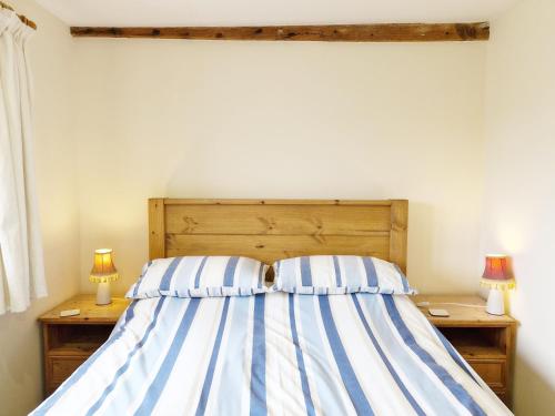 a bedroom with a bed with blue and white stripes at The Dairy , Petersfield in Petersfield