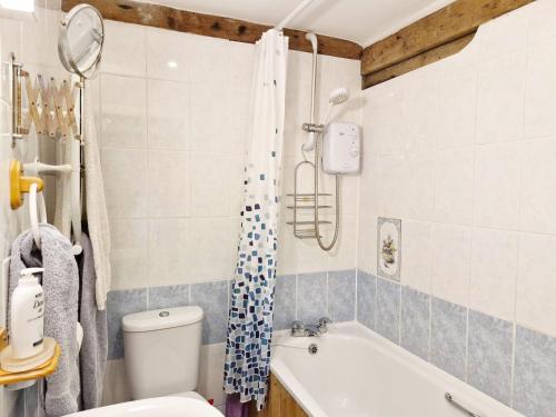 a bathroom with a tub and a toilet and a shower at The Dairy , Petersfield in Petersfield