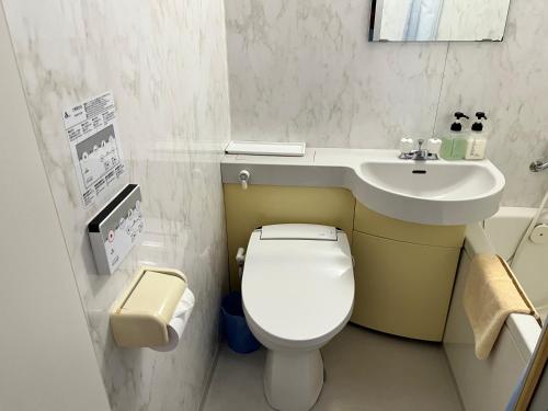 ein kleines Bad mit WC und Waschbecken in der Unterkunft ペンションパティオハウスリーフ 