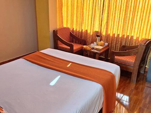 a hotel room with a bed and a table and chairs at Chaska valle Inn in Urubamba