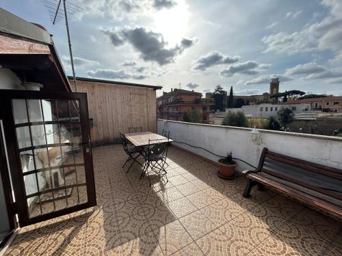 a patio with a bench and a table on a balcony at Ale e Nau in Rome