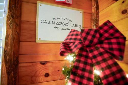 a red and black plaid bow on a christmas tree at Charming Lakeview Cabin Near Geneva-On-The-Lake! in Ashtabula