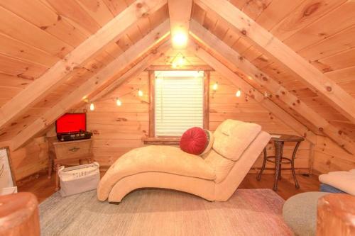 Charming Lakeview Cabin Near Geneva-On-The-Lake! في أشتابولا: غرفة معيشة مع أريكة في العلية