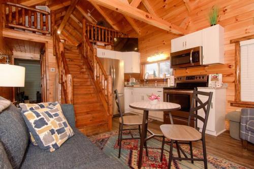 Charming Lakeview Cabin Near Geneva-On-The-Lake! في أشتابولا: غرفة معيشة مع أريكة وطاولة في كابينة