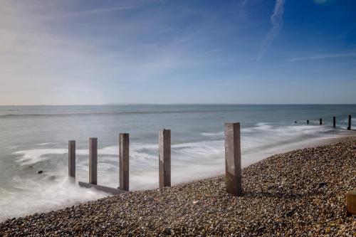 a group of wooden posts on the beach at 4BR Beach House sleeps 10 - 5 mins walk to the Sea in West Wittering