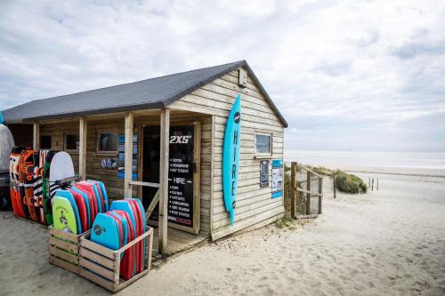 a building on the beach with surfboards at 4BR Beach House sleeps 10 - 5 mins walk to the Sea in West Wittering