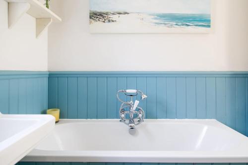een badkamer met een fiets in het midden van een bad bij 4BR Beach House sleeps 10 - 5 mins walk to the Sea in West Wittering
