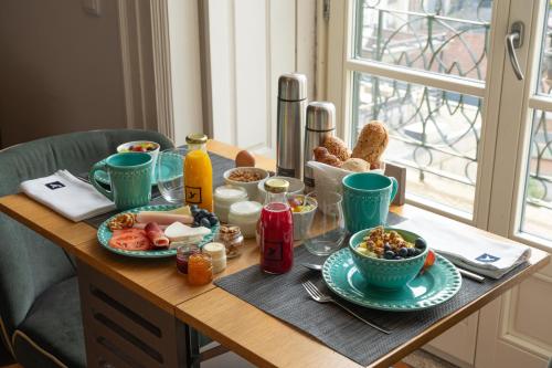 a table with plates of food on top of it at Santa Catarina FLH Suites in Porto